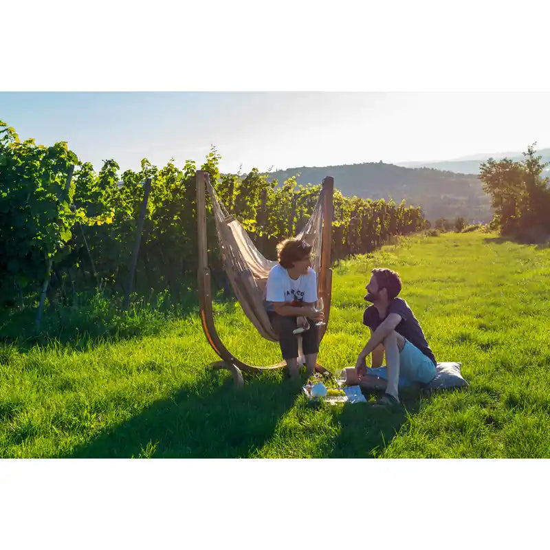 Udine Outdoor Almond - Weather-Resistant Hammock Chair with FSC® certified Eucalyptus Stand – two people relaxing in a garden