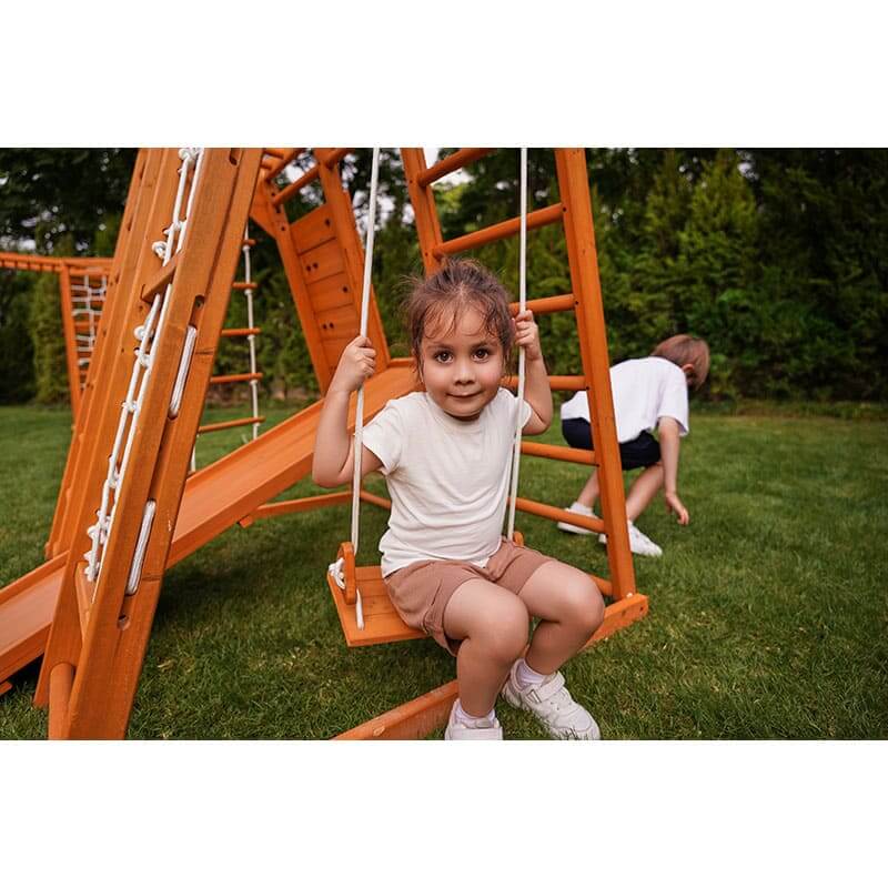 magnolia_outdoor_and_indoor_real_wood_7_in_1_playset_girl_on_swing
