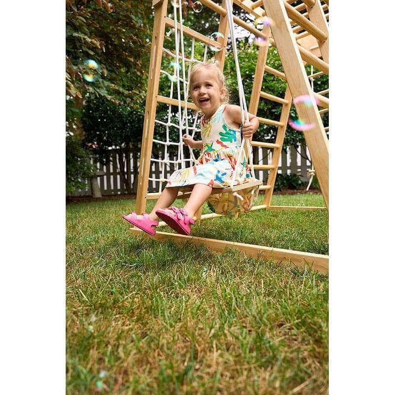 magnolia_outdoor_and_indoor_real_wood_7_in_1_playset_girl_on_swing_smiling