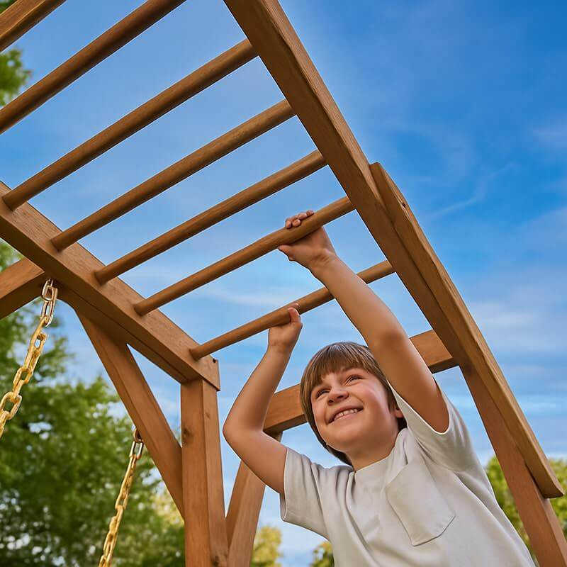 monkey bars on wooden swing set hawthorn xl with boy playing