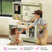 Tiny Land® BistroSwitch Play Kitchen – Two children sharing pretend food beside the Green kitchen