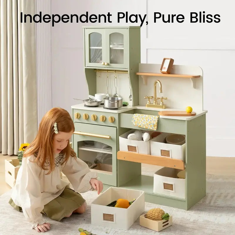 Tiny Land® Wooden Play Kitchen with Storage for Creative Toddlers – Child sitting beside Sage kitchen with a removable storage bin