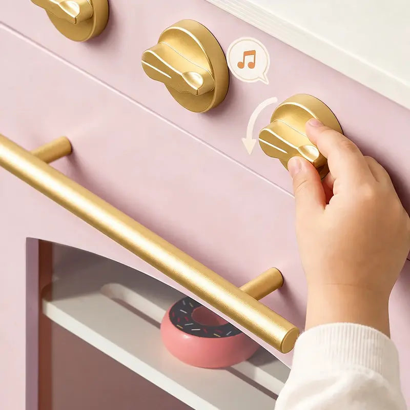 Tiny Land® Wooden Play Kitchen with Storage for Creative Toddlers – Close-up of a hand turning a Sakura Pink kitchen knob