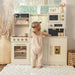 tiny_land_iconic_kitchen_cream_front_view_toddler_playing