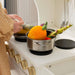 tiny land play kitchen in cream with a pot on the stove